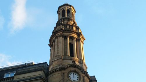 Low angle view of clock tower against blue sky