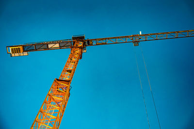 Low angle view of crane against blue sky