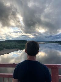 Rear view of man looking at mountain against sky