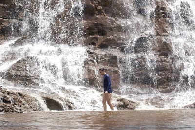 Full length of man standing on rock in sea