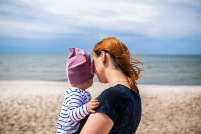 Woman wearing sunglasses at beach against sky