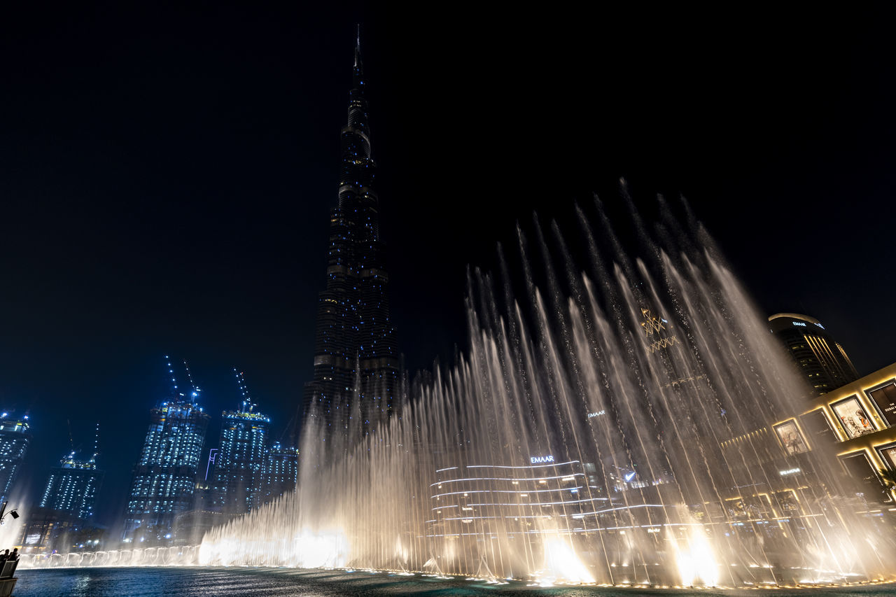 LOW ANGLE VIEW OF ILLUMINATED BUILDINGS AGAINST SKY