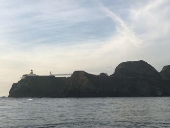 Scenic view of sea and mountains against sky