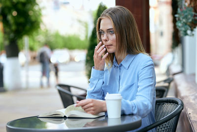 Young woman using mobile phone in cafe