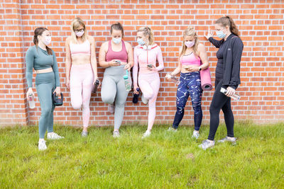 Group of friends standing on grassy field