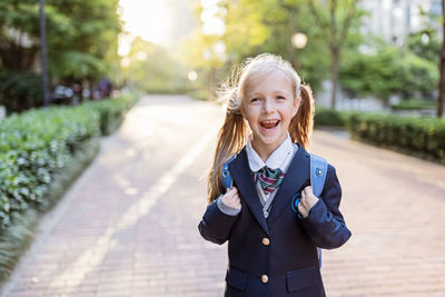 Back to school. little girl with blue backpack from elementary school outdoor