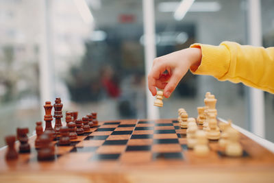 Midsection of man playing with chess against blurred background