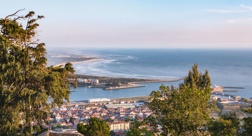 High angle view of city by sea against sky