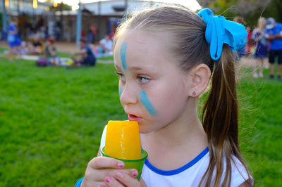 Close-up portrait of cute girl eating outdoors