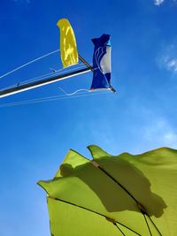 Low angle view of flag against blue sky