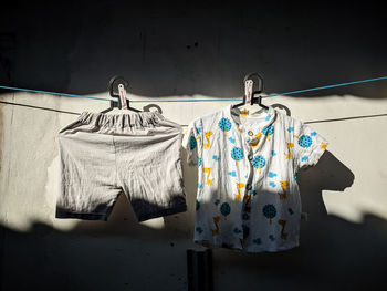 Clothes drying on rope against wall