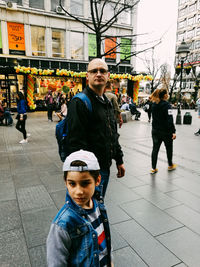 Portrait of father with son on street in city