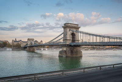 Bridge over river against sky during sunset