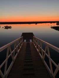 Pier over sea against sky during sunset