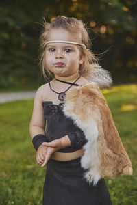 Funny baby dressed in the clothes of primitive people