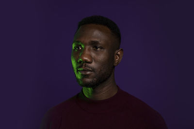 Portrait of young man against black background