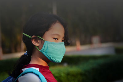 Girl with n95 mask protection from pm 2.5 dust crisis at school in pollution concept
