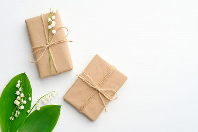 High angle view of box tied up on table against white background