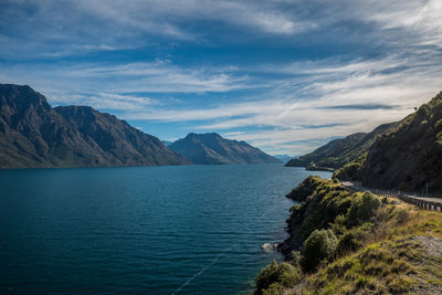 Scenic view of sea and mountains against sky