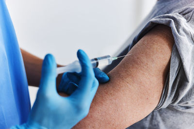 Midsection of doctor vaccinating patient