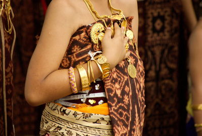 Close-up of woman hand holding jewelry and gringsing cloth from the tenganan,  bali, indonesia.