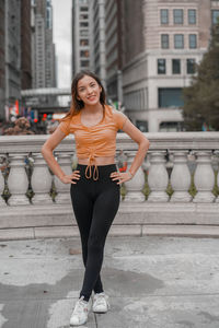 Portrait of young woman standing against wall