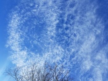 Low angle view of bare tree against cloudy sky