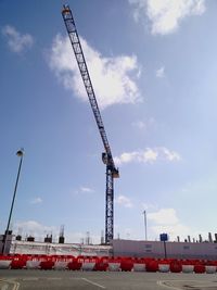 Cranes at construction site against sky