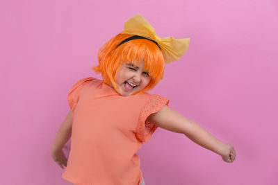 Close-up of woman against pink background