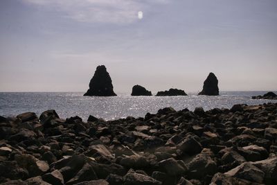 Rocks on beach against sky