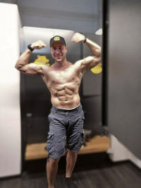 Full length of shirtless man looking at camera