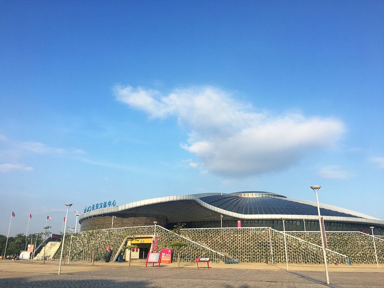 sky, built structure, cloud - sky, sport, architecture, nature, day, blue, land, outdoors, building exterior, beach, team sport, soccer, sand, sunlight, net - sports equipment, volleyball - sport, plant, beach volleyball