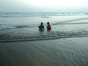 People on beach against sky