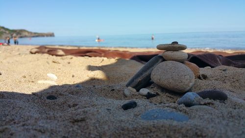 Close-up of pebbles on beach against sky