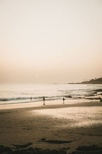 Scenic view of beach against clear sky during sunset