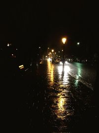 Reflection of illuminated lights in puddle