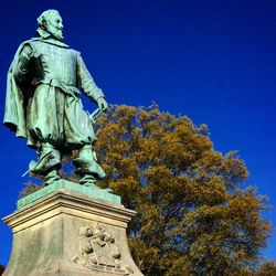 Low angle view of statue against blue sky