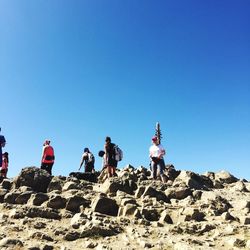 Low angle view of people on cliff