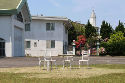 Plants and chairs on street against building