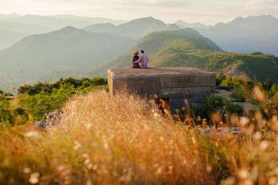 Couple on built structure against mountain range