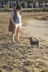 Rear view of woman standing at beach