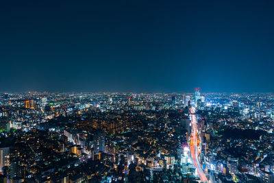 High angle view of city lit up at night