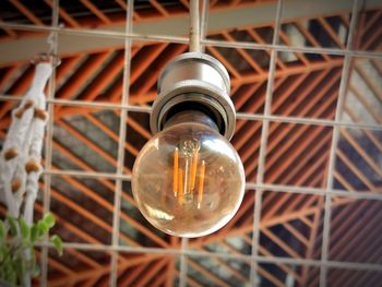 Low angle view of light bulb hanging from ceiling