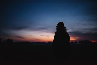 Silhouette woman standing against sky during sunset