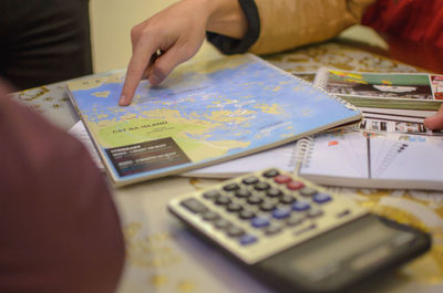 Close-up of hand holding book on table