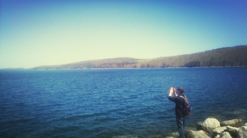 water, clear sky, lifestyles, leisure activity, copy space, blue, tranquility, tranquil scene, scenics, beauty in nature, rear view, men, mountain, standing, nature, lake, vacations, full length