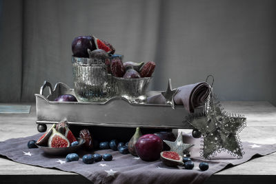 Close-up of christmas decorations and fruits with containers on table