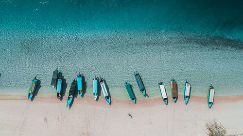 High angle view of multi colored umbrellas on sand against blue sky