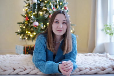 Portrait of young woman sitting on sofa at home