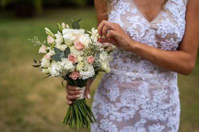 Midsection of woman holding white flower